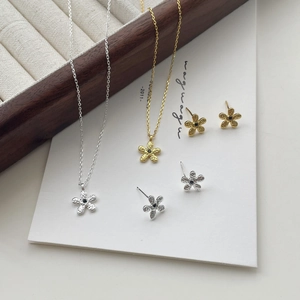 Détail du collier fleur avec texture martelée et incrustation centrale de gemme noire