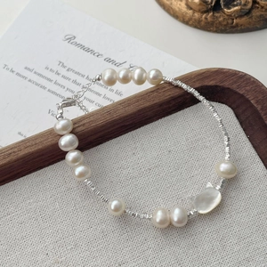 Detailed macro view of S925 silver beaded bracelet with freshwater pearls and shell cat charm