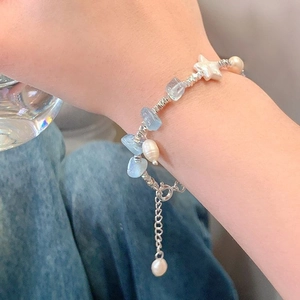 Dettaglio del bracciale con pietre acquamarina, perla a stella barocca e catena argento