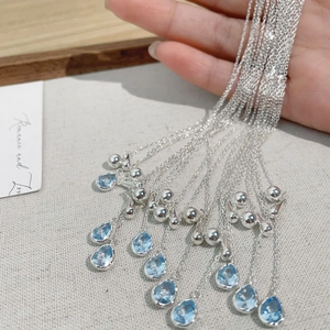 Macro shot of S925 silver necklace with blue teardrop cubic zirconia pendant and beads