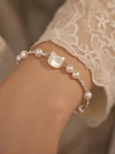 Close-up of S925 silver bracelet with natural shell cat charm and freshwater pearls