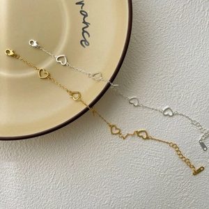 Detailed macro of S925 silver heart bracelets in gold and silver with lobster clasp