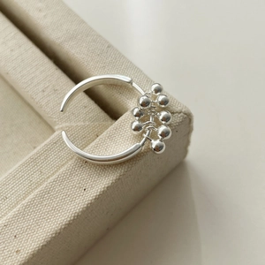 Detail of S925 sterling silver ring with polished bead tassels and open band design