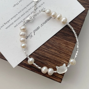 Close-up of freshwater pearl bracelet with S925 silver beads and a shell cat charm