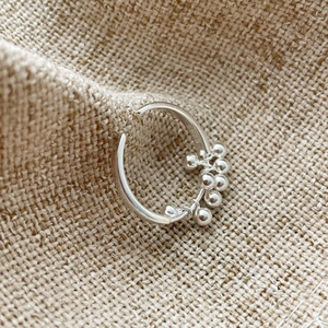 Detail of S925 sterling silver ring with polished bead charms and adjustable open band