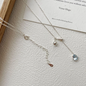 Detail of S925 silver Y-shaped necklace featuring a light blue water drop gemstone