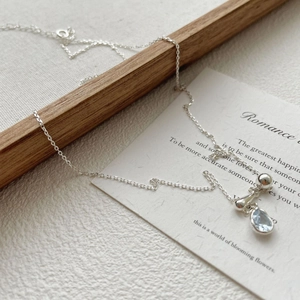 Detail of S925 silver necklace with blue teardrop zircon and polished silver pendants