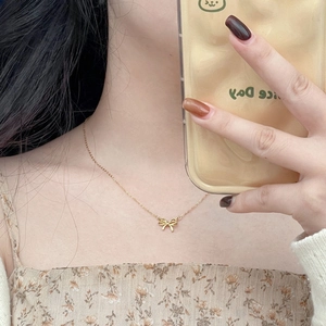 Elegant 925 sterling silver hollow bow necklace in gold worn during a mirror selfie
