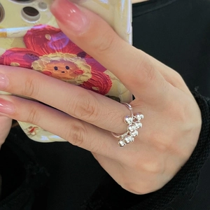 Detail view of S925 sterling silver ring with dangling polished spheres on hand
