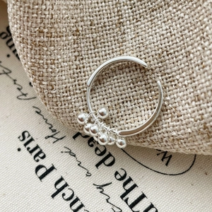 Macro shot of S925 sterling silver ball cluster ring on natural linen background