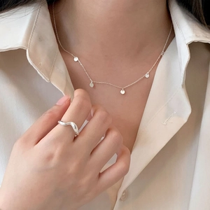 Detailed view of minimalist 925 sterling silver mini round necklace and wavy ring set