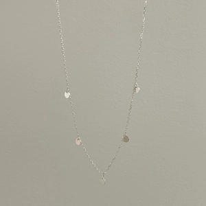 Detailed macro view of minimalist 925 sterling silver chain with five round disk pendants