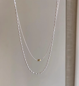 Dettaglio della collana a strati in argento S925 con perla dorata e maglie ovali lisce