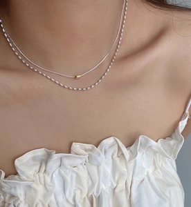 Dettaglio della collana a strati in argento S925 con perline dorate e maglie a oliva