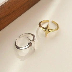 Macro shot of minimalist adjustable open rings with polished star patterns in gold and silver