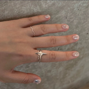 Detail showing a S925 sterling silver star ring set with elegant wavy band design