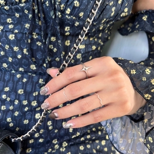 Close-up of minimalist S925 silver star ring and wavy bands set on a finger