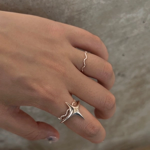 Detail of S925 silver wave ring with glitter and large 3D star ring worn together