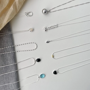 Flat lay of S925 silver necklaces with black agate hearts and blue gemstone pendants