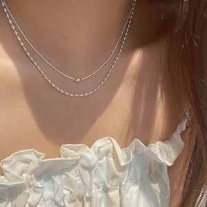 Elegante collana a doppio strato in argento con perla dorata e grani ovali