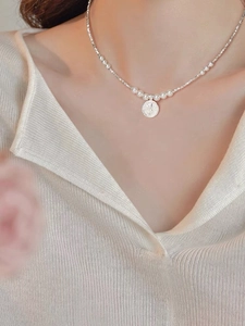 Close-up of S925 silver necklace with round pearls and rose flower embossed coin pendant
