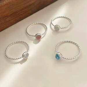 Détail de quatre bagues en argent S925 torsadées avec mini cristaux multicolores