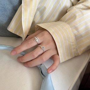 Gros plan de bagues en argent S925 avec gemme de cristal bleu et motif fleur creuse