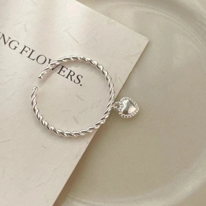 Detailed macro view of S925 sterling silver twist rope ring with heart pendant