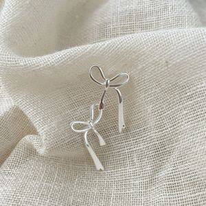 Boucles d'oreilles nœud papillon en argent sterling S925 sur fond de lin texturé
