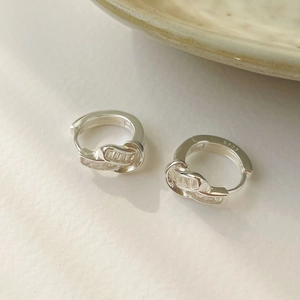 Macro shot of S925 sterling silver knotted earrings with sparkling zircon inlay details