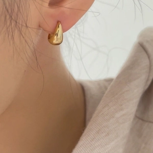 Minimalist golden teardrop S925 sterling silver earrings worn by a model in high detail
