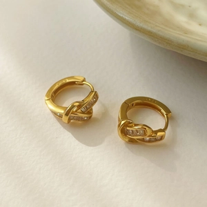 Close-up of S925 sterling silver gold-plated knot earrings with zircon inlay detail