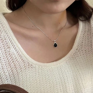 Close-up of S925 silver necklace with black agate teardrop pendant on a model
