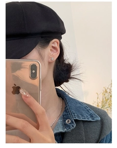 Boucles d'oreilles minimalistes en argent S925 avec smiley portées en selfie miroir