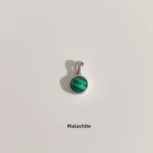 Détail d'un pendentif rond en malachite verte avec rayures sur monture en argent S925