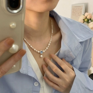 Elegant S925 sterling silver pearl necklace with blue gemstone pendant worn on neck