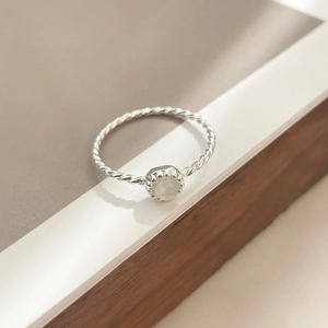Détail de la bague en argent 925 avec anneau torsadé et pierre de lune blanche ronde