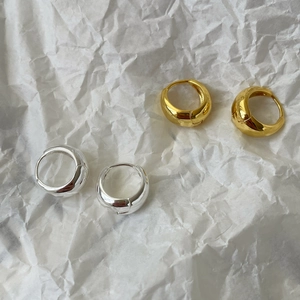 Close-up of teardrop curved hoop earrings in polished gold and silver metallic finishes
