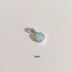Gros plan d'un pendentif rond minimaliste en opale et argent sterling S925 poli brillant