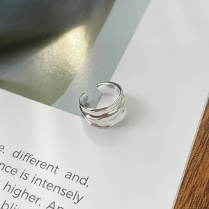 Macro shot of silver irregular wave textured ring on minimalist magazine background