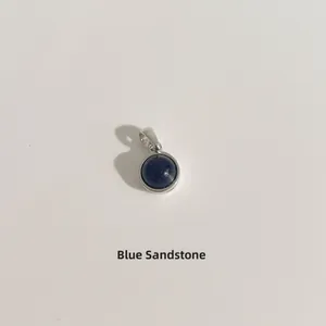 Vue détaillée d'un pendentif rond en pierre de sable bleu scintillant monté en argent