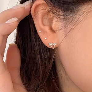 Élégant ensemble de boucles d'oreilles nœud et perle en argent S925 porté par femme