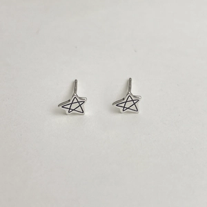 Détail de boucles d'oreilles puces étoiles en argent S925 avec contour noir interne