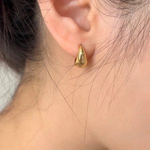 Close-up of polished gold teardrop earrings for women showing high-shine metallic finish