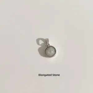 Macro d'un pendentif rond en pierre de labradorite serti dans un cadre en argent fin S925