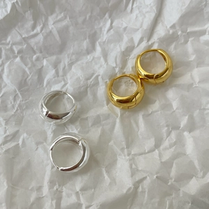 Detail of minimalist thick oval hoop earrings in polished gold and silver finishes
