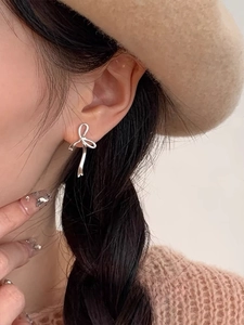 Gros plan de boucles d'oreilles nœud papillon en argent S925 avec pampilles sur modèle