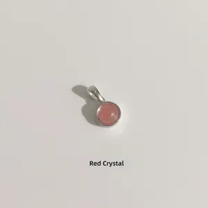Détail macro d'un pendentif rond en cristal rouge monté sur argent sterling S925