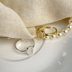 Minimalist 925 sterling silver open ring with oval chalcedony set on a white ceramic dish