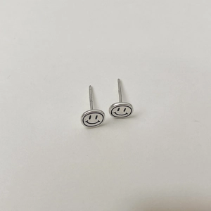 Gros plan sur les puces d'oreilles smiley en argent sterling S925 avec poinçon gravé